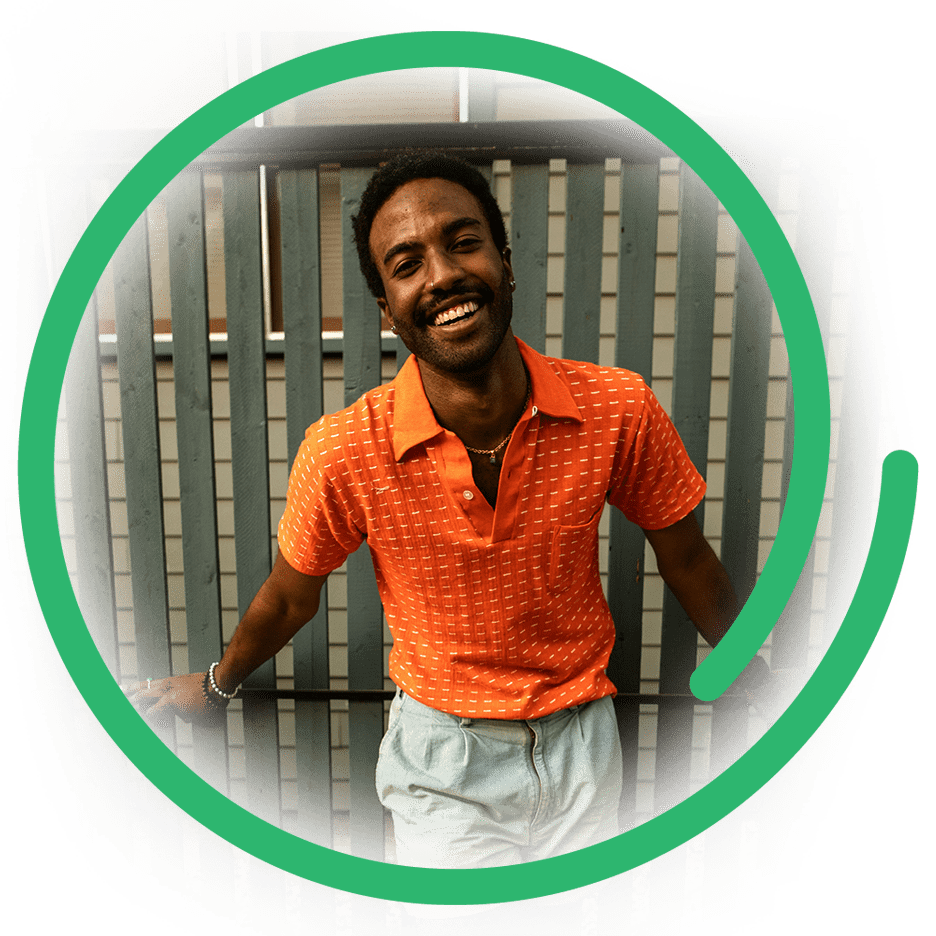 a photo of a happy, black, gay man in an orange shirt